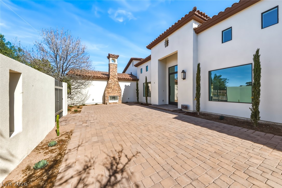 1140 Julie Road Henderson, NV 89002 - Photo 6 of 38 Behind the gate a private walled courtyard offers an outdoor fireplace, extensive paver patio, and landscaping that complements the striking modern facade.