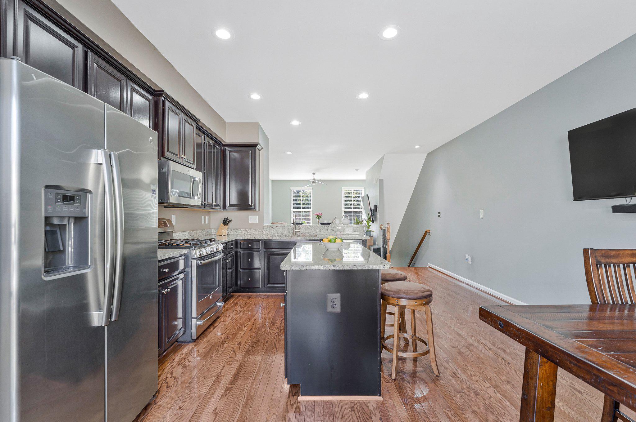 24977 Coats Square Aldie, VA 20105 - Photo 13 of 32 a kitchen with stainless steel appliances granite countertop a refrigerator a stove top oven a sink dishwasher and wooden cabinets with wooden floor