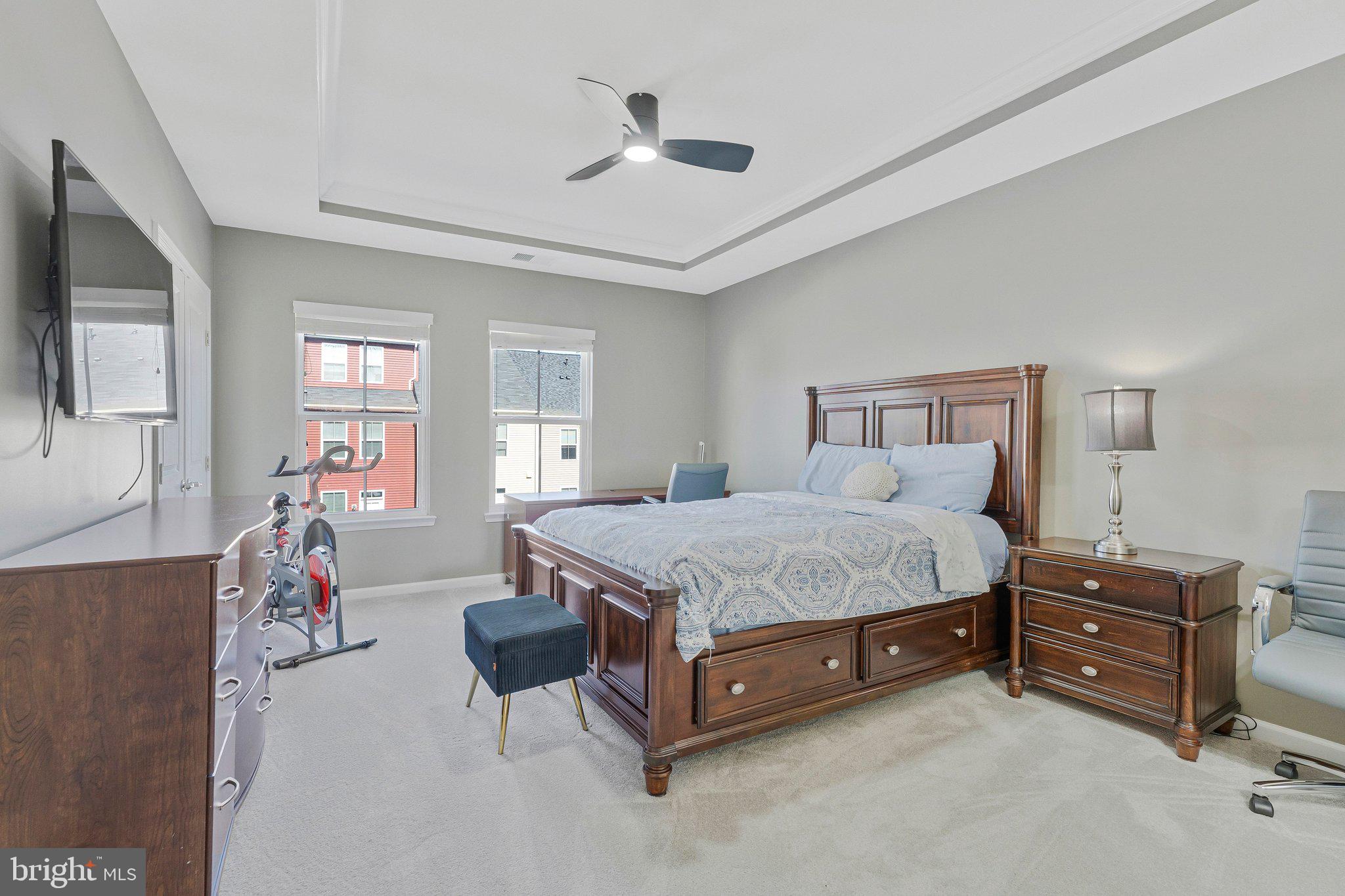 24977 Coats Square Aldie, VA 20105 - Photo 21 of 32 a spacious bedroom with a bed and a flat tv screen on dresser