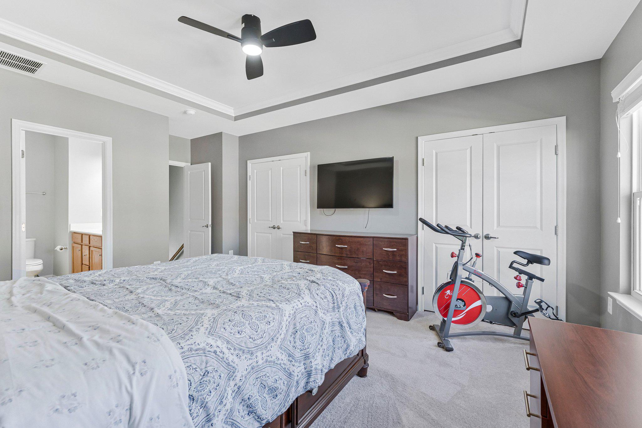 24977 Coats Square Aldie, VA 20105 - Photo 23 of 32 a bedroom with a bed a flat screen tv and a chandelier