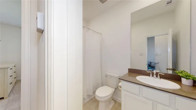 a bathroom with a granite countertop sink toilet and a mirror
