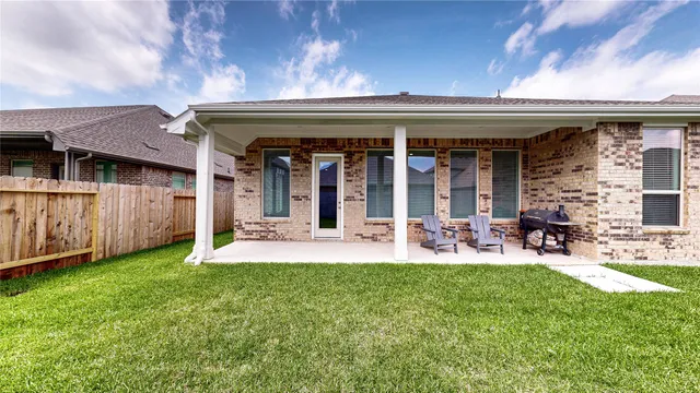 a view of a patio with table and chairs with wooden fence