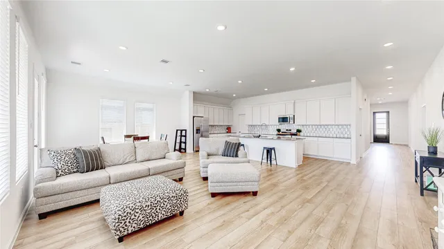 a living room with furniture and view of kitchen