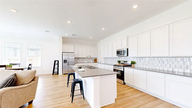 a kitchen with white cabinets and stainless steel appliances