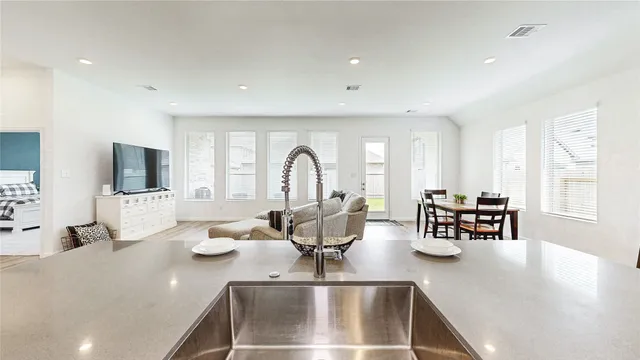 a kitchen with a large window cabinets and living room view