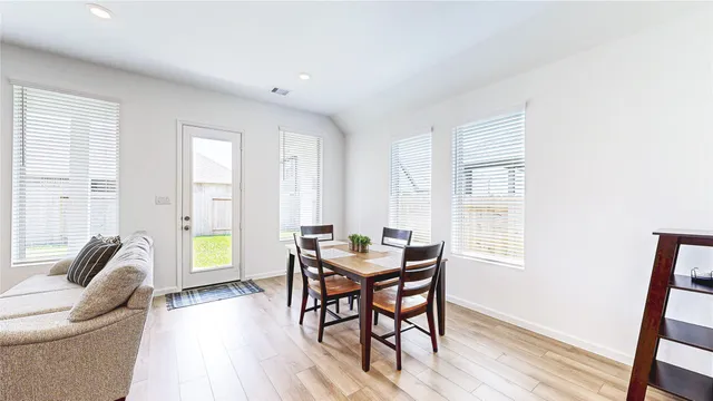 a dining room with furniture and wooden floor