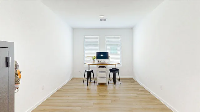a workspace with furniture wooden floor and a window
