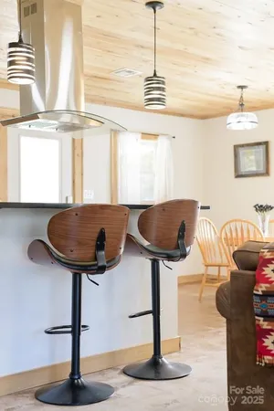 a kitchen with a chandelier and living room view