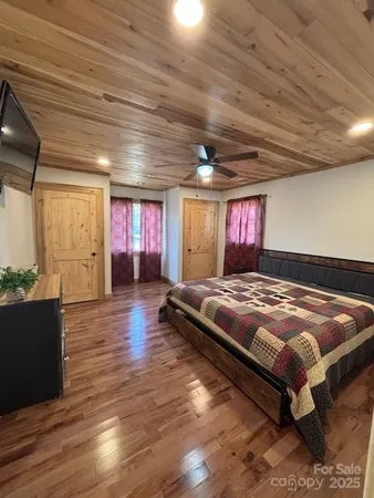 a spacious bedroom with a bed and wooden floor