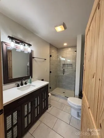 a bathroom with a double vanity sink toilet mirror and shower