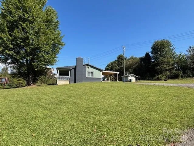 a front view of a house with a yard and trees