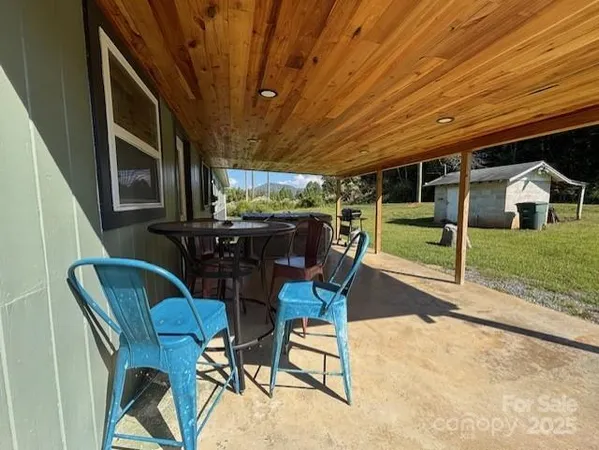 a view of a porch with furniture and backyard