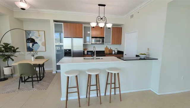 a kitchen with kitchen island granite countertop a table and chairs in it