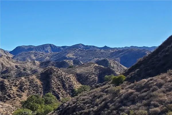 a view of mountains in middle of the green field
