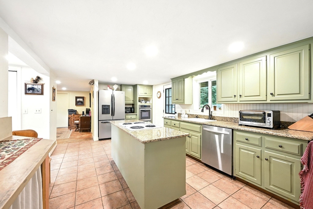 23 Westboro Road Upton, MA 01568 - Photo 7 of 42 a large kitchen with kitchen island a sink a stove and cabinets