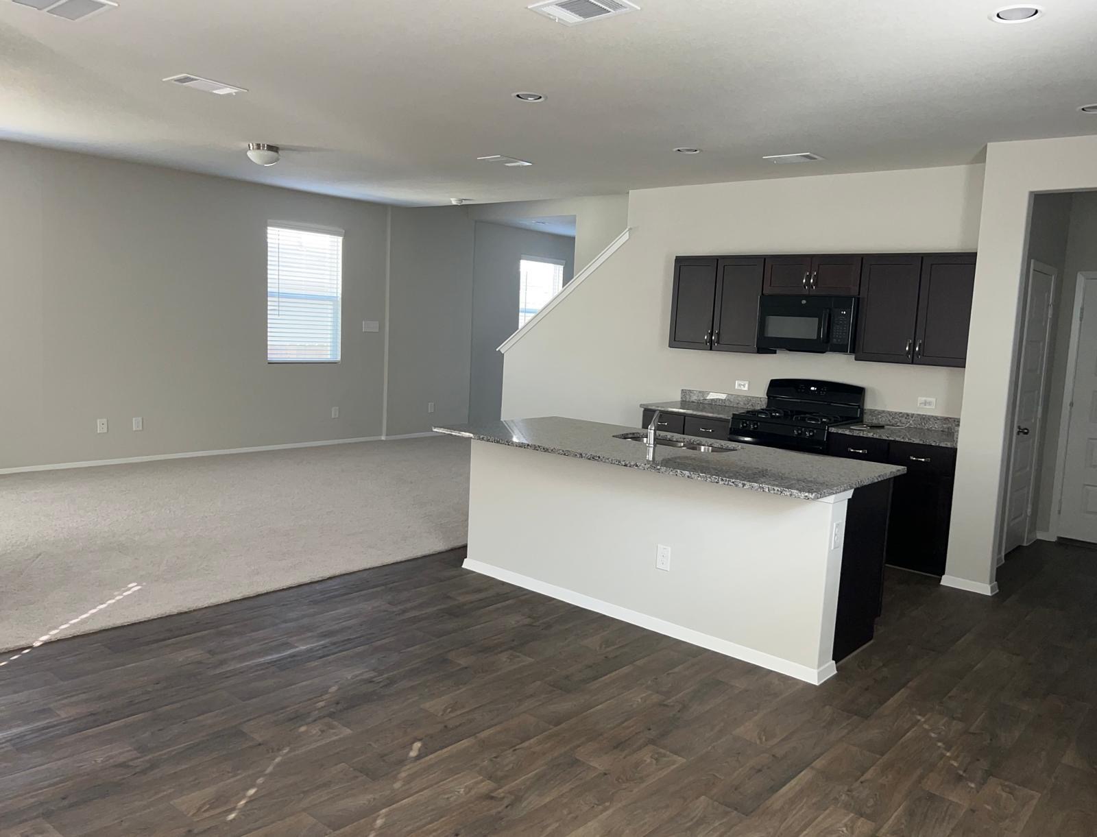 11516 Murano Drive Austin, TX 78747 - Photo 2 of 23 a kitchen with granite countertop a stove and a refrigerator