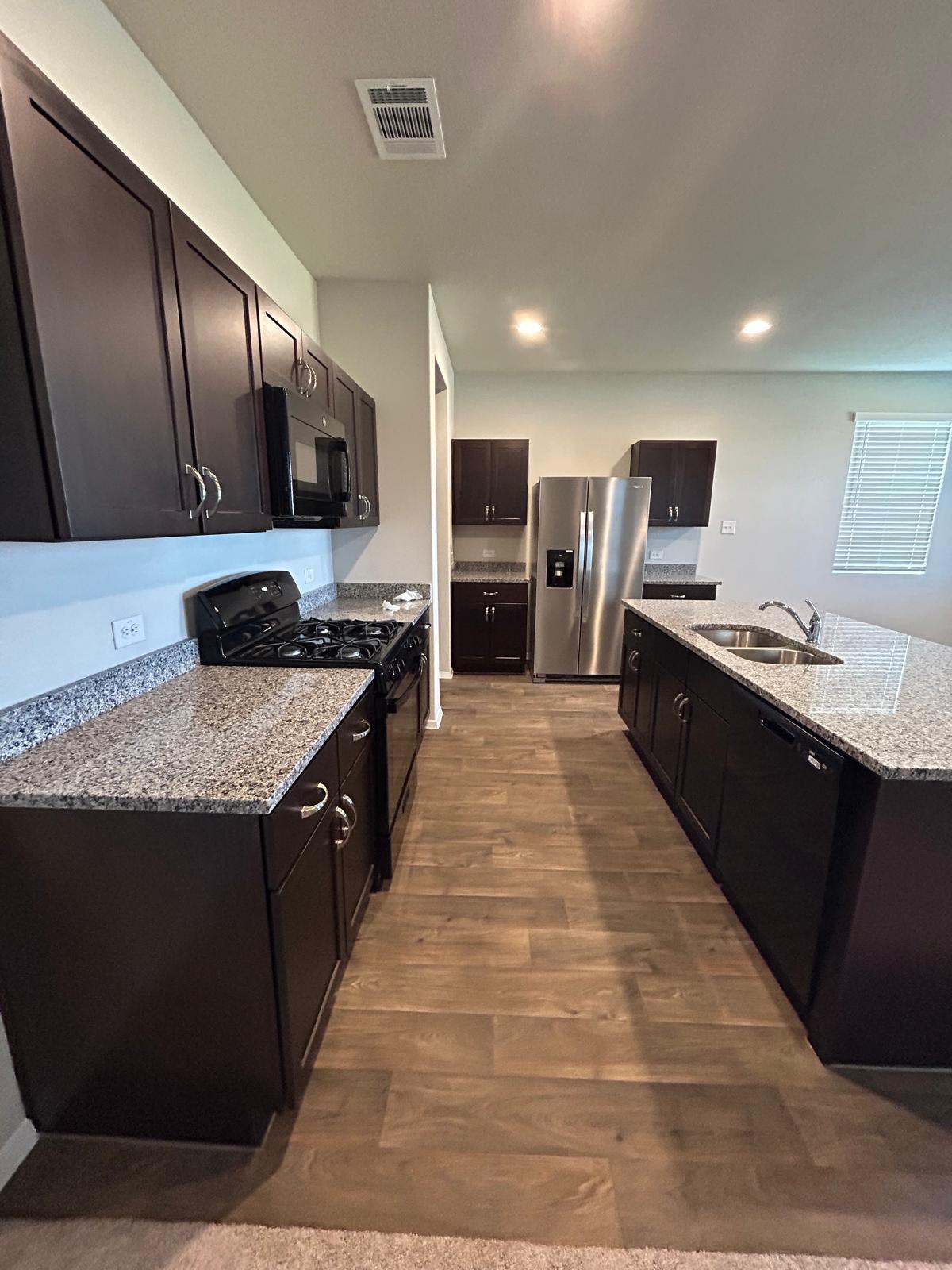 11516 Murano Drive Austin, TX 78747 - Photo 5 of 23 a kitchen with stainless steel appliances granite countertop a stove a sink dishwasher a refrigerator and a oven