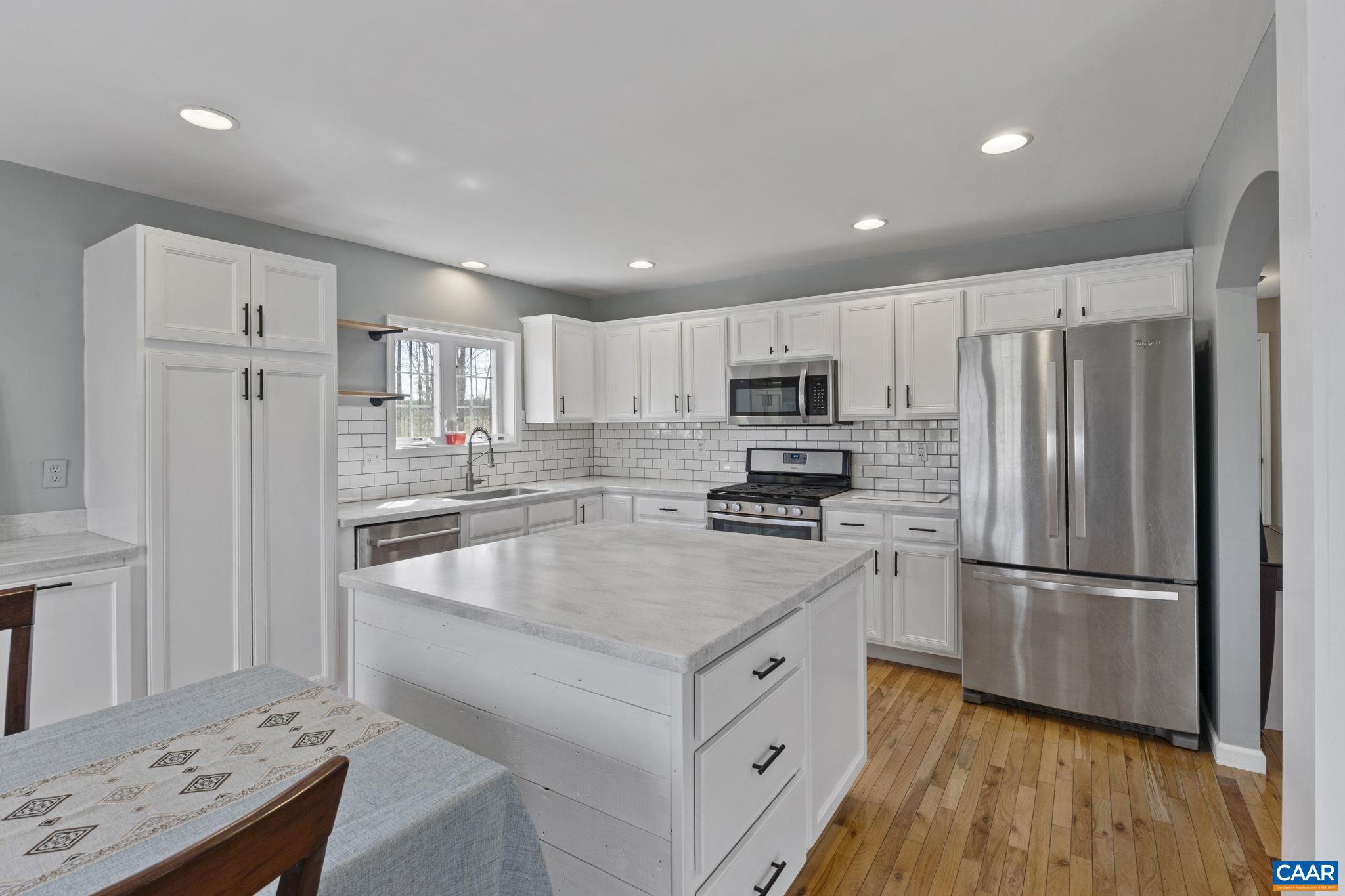379 Fox Ridge Lane Palmyra, VA 22963 - Photo 13 of 42 a kitchen with kitchen island granite countertop appliances cabinets a sink and a center island