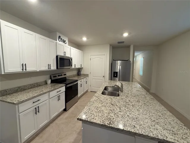 a kitchen with a sink stove top oven and refrigerator