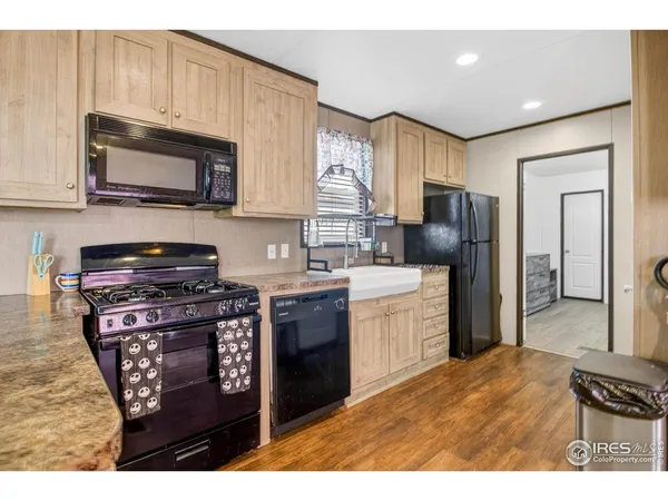 a kitchen with stainless steel appliances granite countertop a stove a sink dishwasher a refrigerator and a microwave