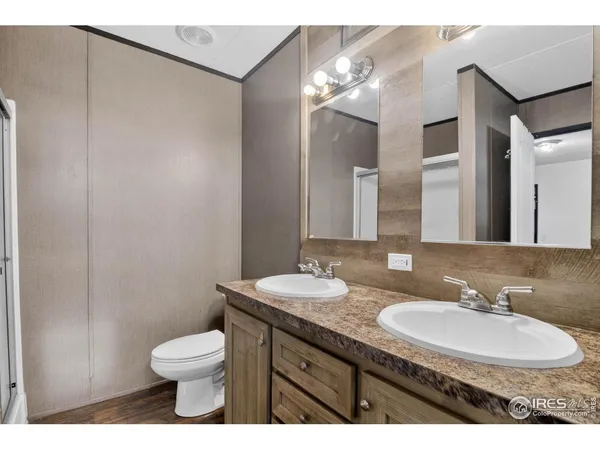 a bathroom with a granite countertop sink a toilet and a mirror