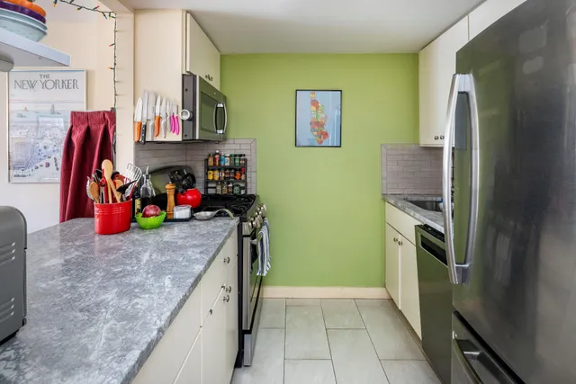 a kitchen with stainless steel appliances granite countertop a refrigerator and a stove top oven