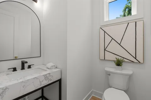 a bathroom with a granite countertop sink a toilet and a mirror
