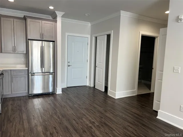 a view of a kitchen with wooden floor electronic appliances and a window