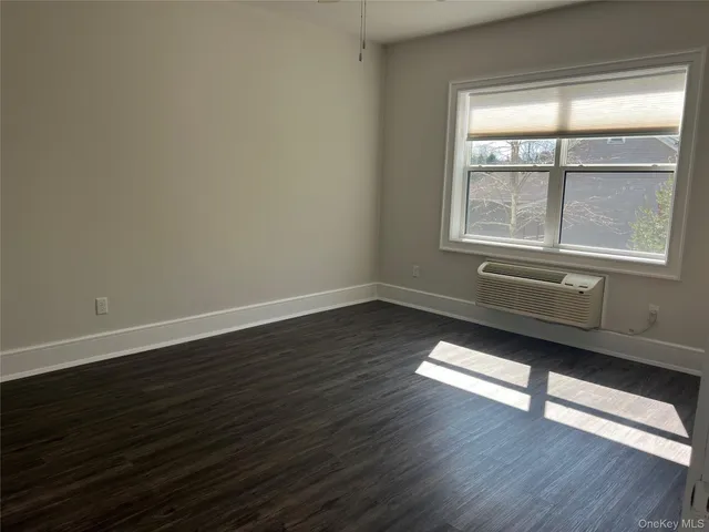 a room with wooden floor and windows