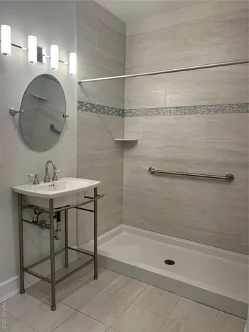a bathroom with a sink shower and a mirror