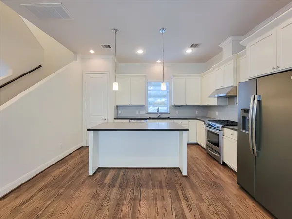 a kitchen with a refrigerator and white cabinets