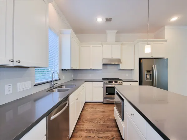 a kitchen with a sink stove top oven and refrigerator