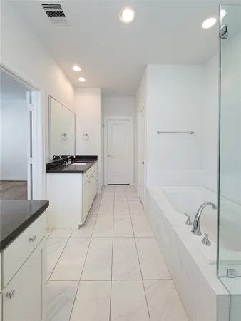 a bathroom with a granite countertop sink a large mirror and shower
