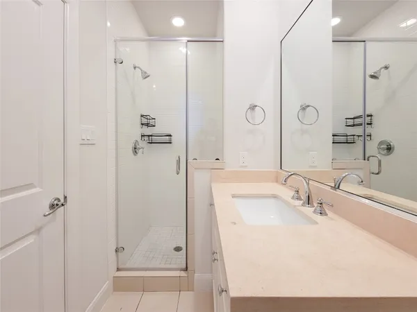 a bathroom with a shower sink vanity and mirror