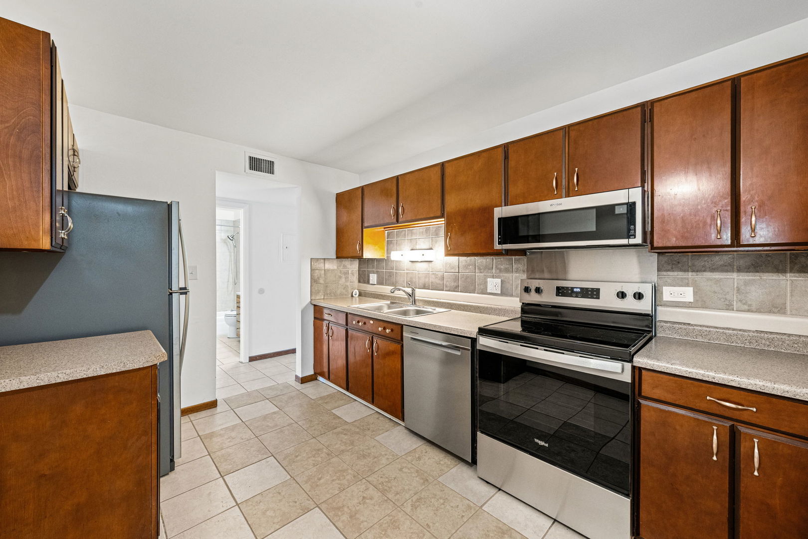 640 Murray Lane, Unit 111 Des Plaines, IL 60016 - Photo 3 of 19 a kitchen with stainless steel appliances granite countertop a stove microwave and sink