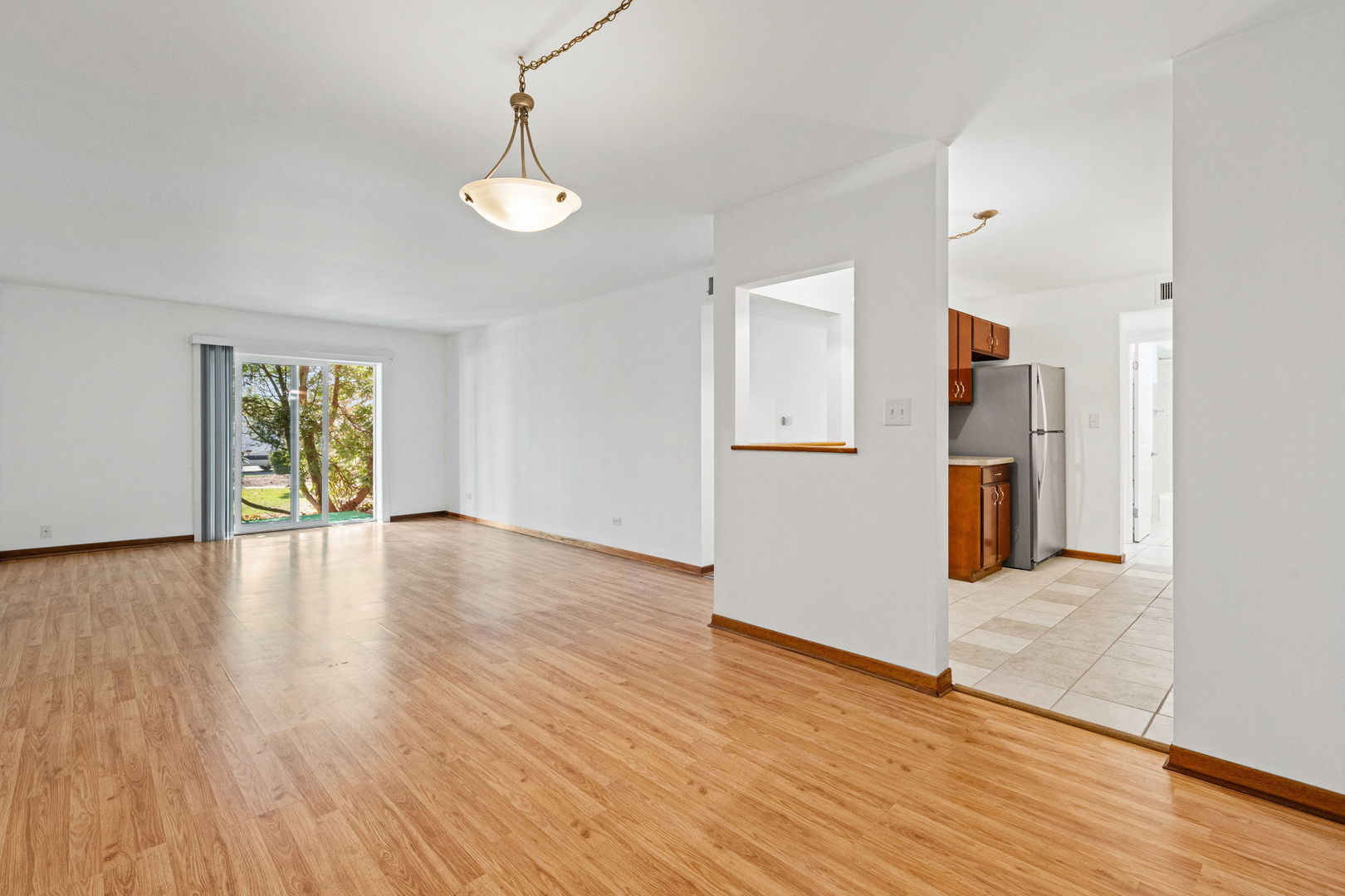 640 Murray Lane, Unit 111 Des Plaines, IL 60016 - Photo 7 of 19 a view of an empty room with window and wooden floor