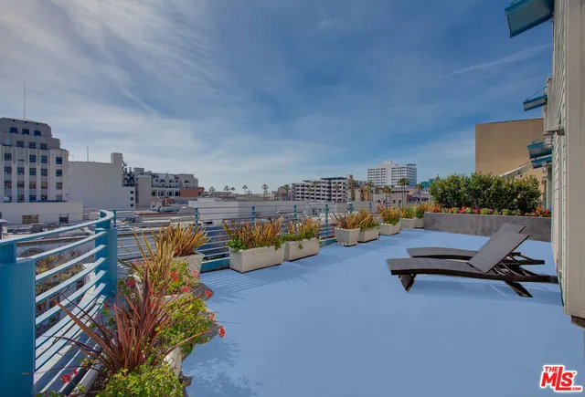 a view of a terrace with lawn chairs