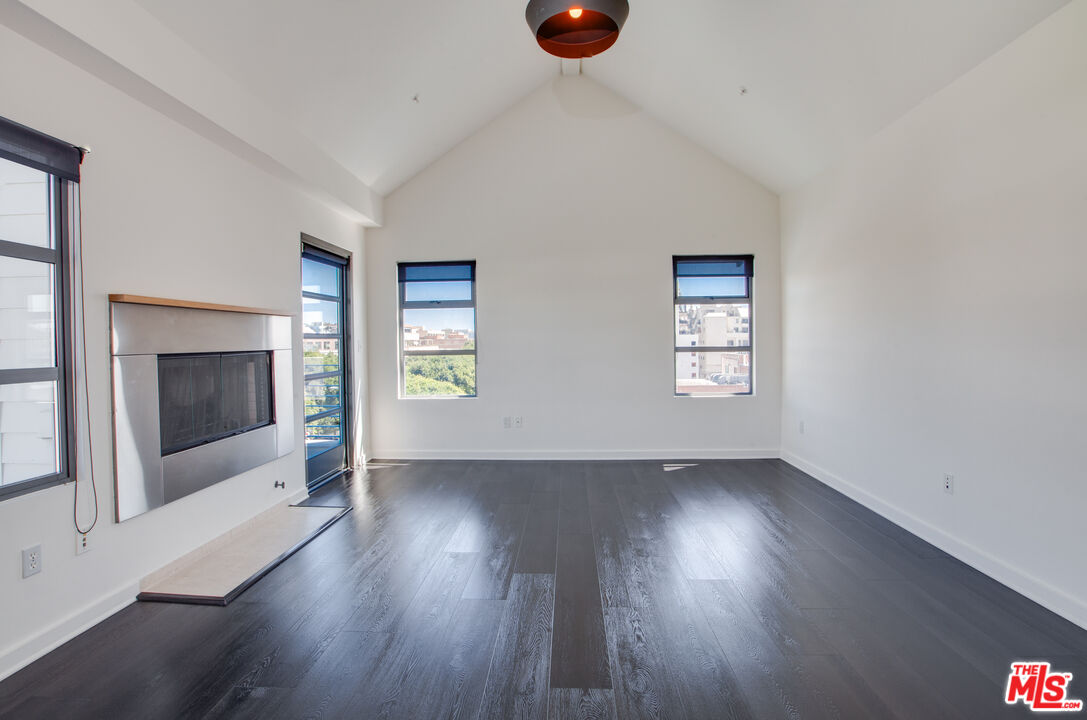 1358 4th Street, Unit A Santa Monica, CA 90401 - Photo 21 of 46 an empty room with wooden floor fireplace and windows
