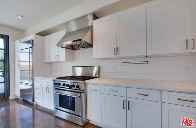 a kitchen with stainless steel appliances a stove and cabinets
