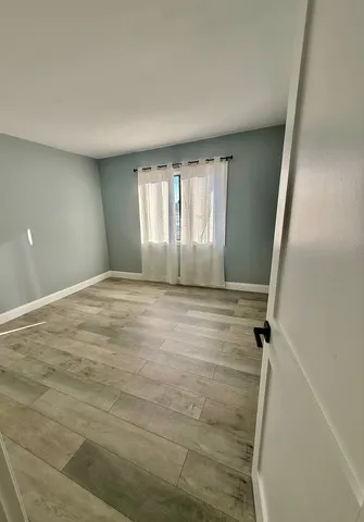a bathroom with a window shower and hardwood floor