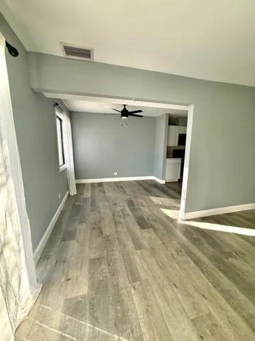 an empty room with a fireplace and windows