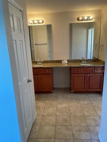a bathroom with a granite countertop bathtub sink and mirror