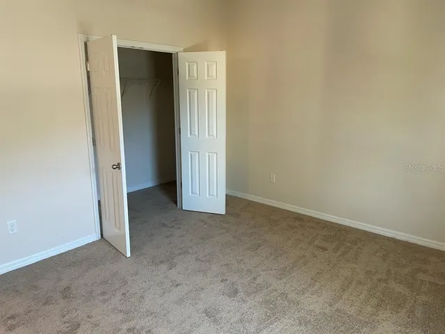 an empty room with windows and a ceiling fan