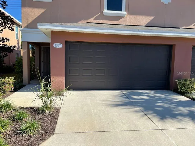 a view of yellow house with potted plants