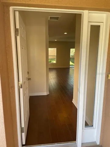 a view of a hallway with wooden floor