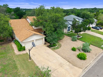 an aerial view of a house with yard and green space