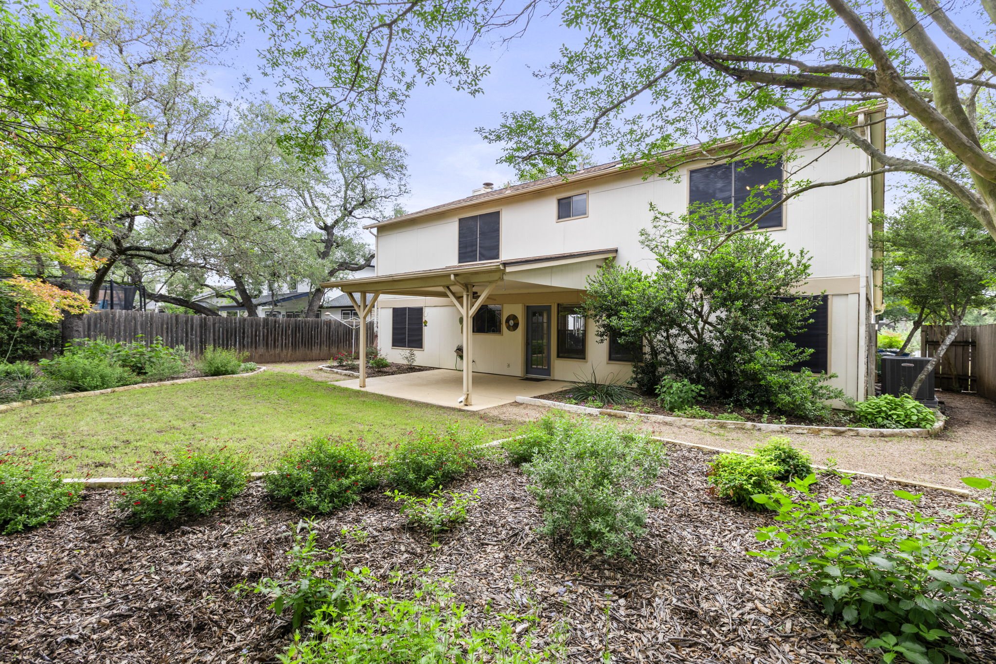 9006 Lockleven Loop Austin, TX 78750 - Photo 2 of 25 a view of a white house with a big yard plants and large tree