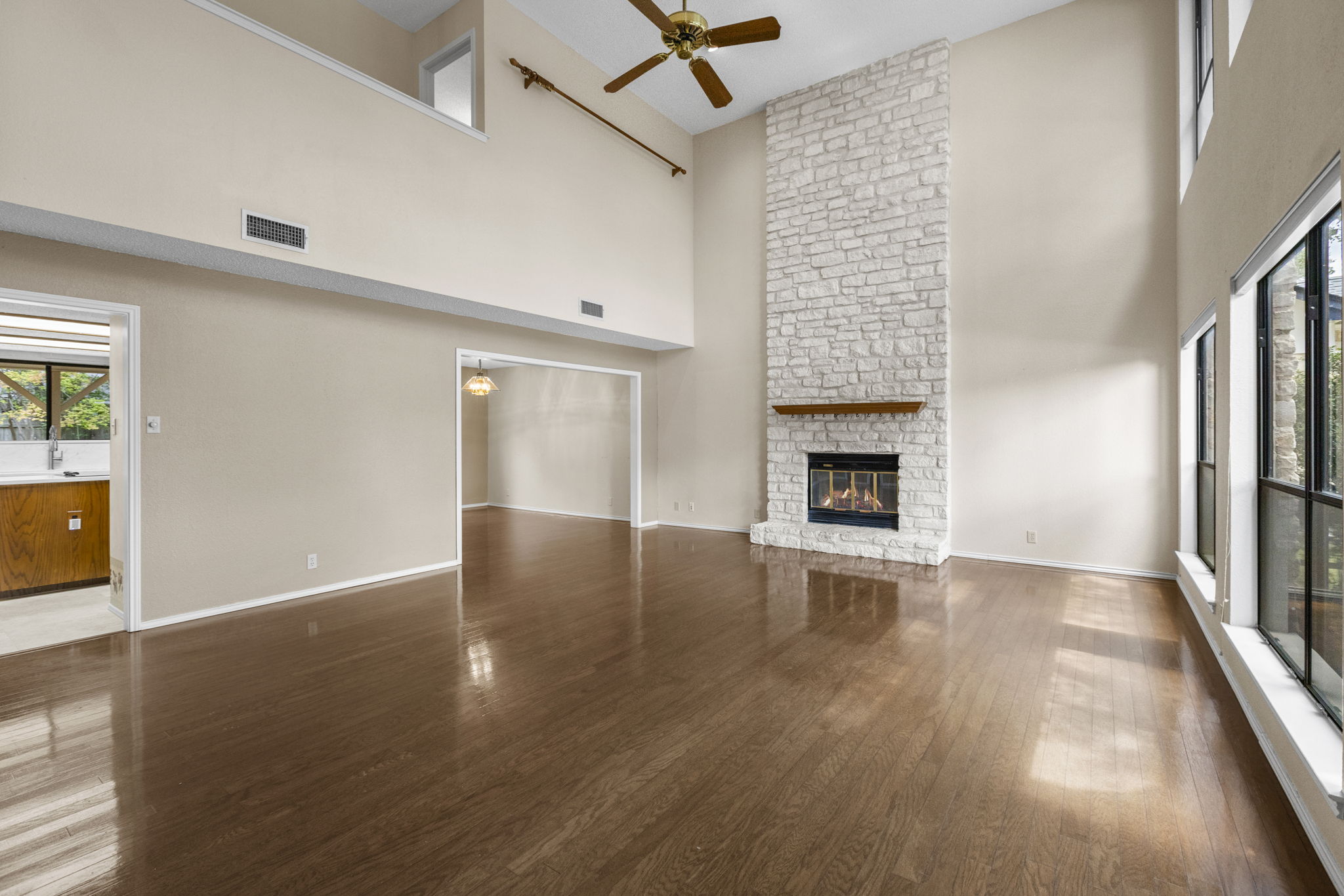 9006 Lockleven Loop Austin, TX 78750 - Photo 6 of 25 an empty room with wooden floor fireplace and windows