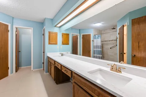 a spacious bathroom with a granite countertop sink and a mirror