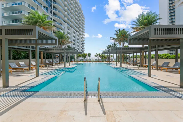 a view of a building with a swimming pool and a yard
